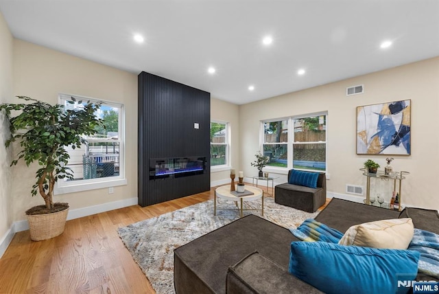 living area featuring wood finished floors, recessed lighting, a fireplace, and baseboards