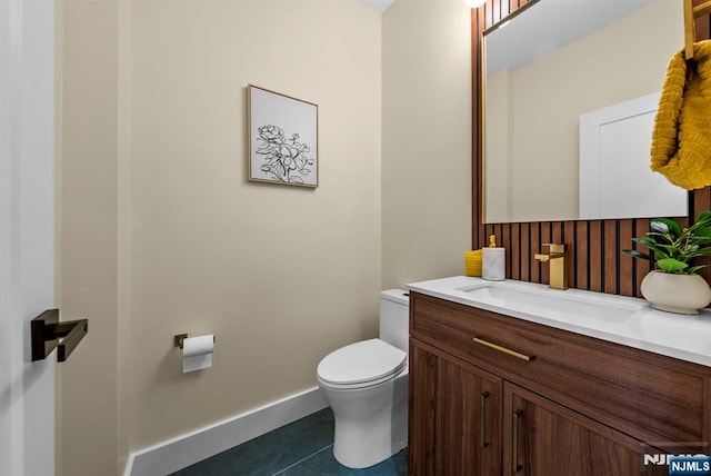 bathroom with toilet, tile patterned flooring, vanity, and baseboards