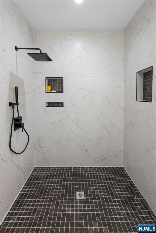 full bathroom featuring tiled shower
