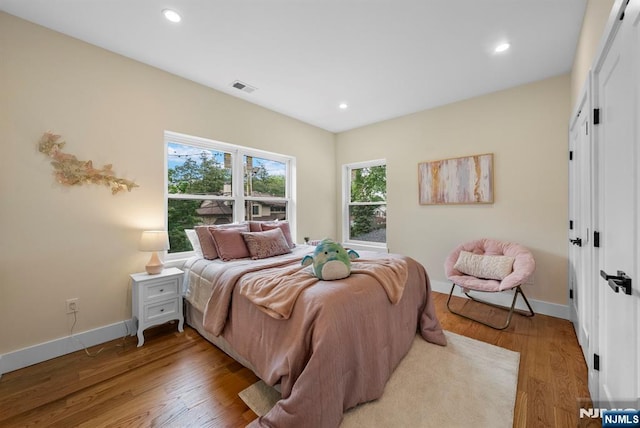 bedroom featuring baseboards, light wood-type flooring, and recessed lighting