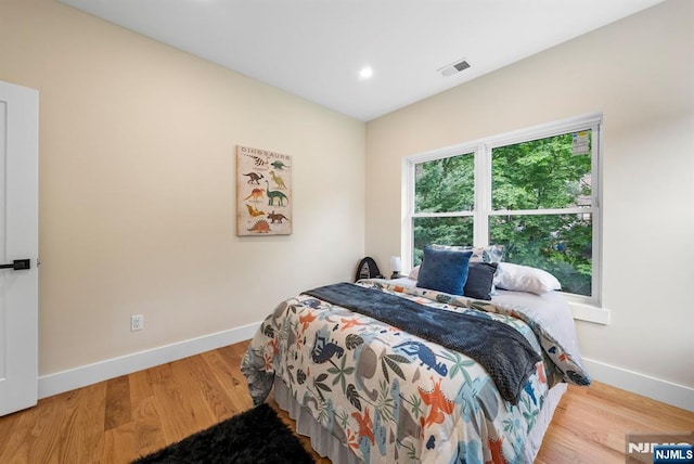 bedroom featuring baseboards, wood finished floors, and recessed lighting