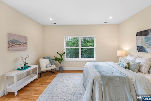 bedroom with light wood-style flooring, baseboards, and recessed lighting