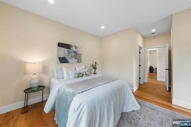 bedroom featuring baseboards, wood finished floors, and recessed lighting