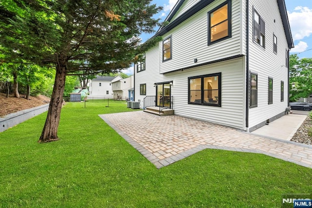 rear view of house with a patio area and central AC unit