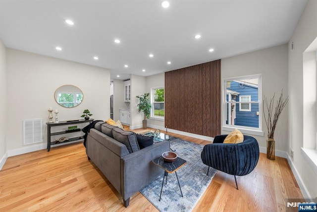 living room with light wood finished floors, recessed lighting, and baseboards