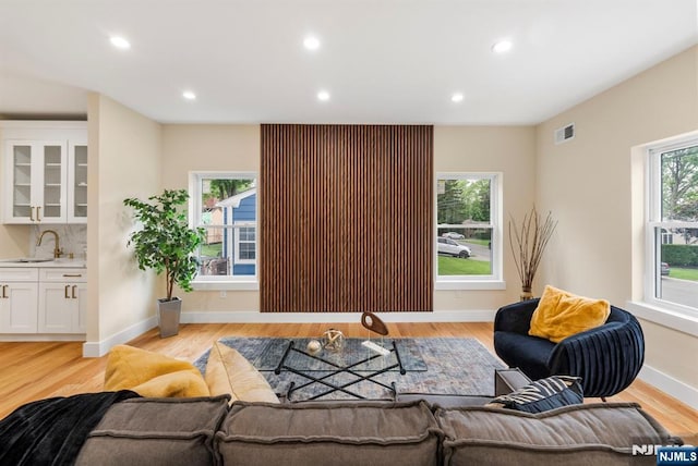 living area with light wood-style flooring, recessed lighting, and baseboards