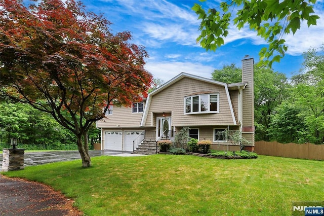 27 Ellen Ln, Wayne, NJ 07470 - split foyer home featuring a chimney, driveway, and an attached garage