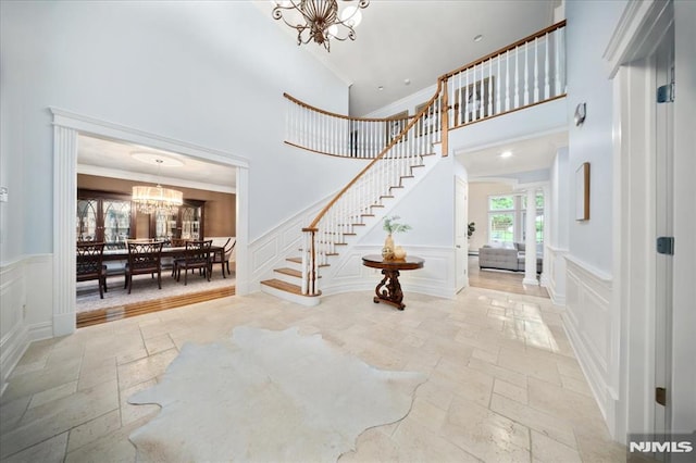 17 Sunset Ln, Upper Saddle River, NJ 07458 - entrance foyer featuring stone tile flooring, a chandelier, a decorative wall, a high ceiling, and stairway