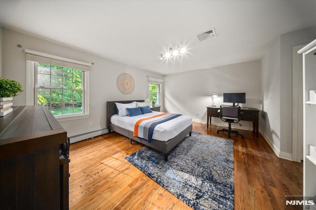 17 Sunset Ln, Upper Saddle River, NJ 07458 - bedroom featuring baseboard heating, multiple windows, an office area, and wood finished floors