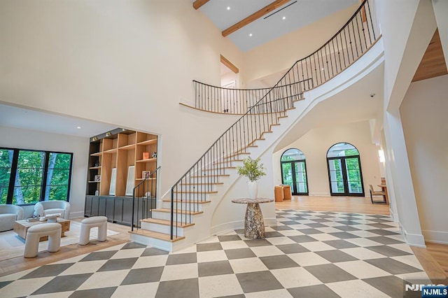 stairs featuring a towering ceiling, recessed lighting, baseboards, and built in shelves