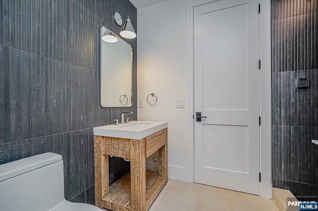 bathroom featuring tile patterned floors, toilet, tile walls, and vanity