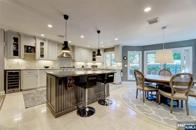 155 W Clinton Ave, Tenafly, NJ 07670 - kitchen with wine cooler, wall chimney exhaust hood, a center island, backsplash, and recessed lighting