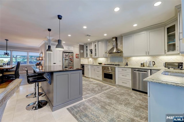 155 W Clinton Ave, Tenafly, NJ 07670 - kitchen with stainless steel appliances, wall chimney exhaust hood, light stone countertops, backsplash, and a kitchen bar