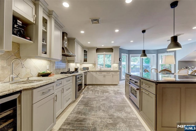 155 W Clinton Ave, Tenafly, NJ 07670 - kitchen with wall chimney range hood, beverage cooler, a sink, stainless steel oven, and tasteful backsplash
