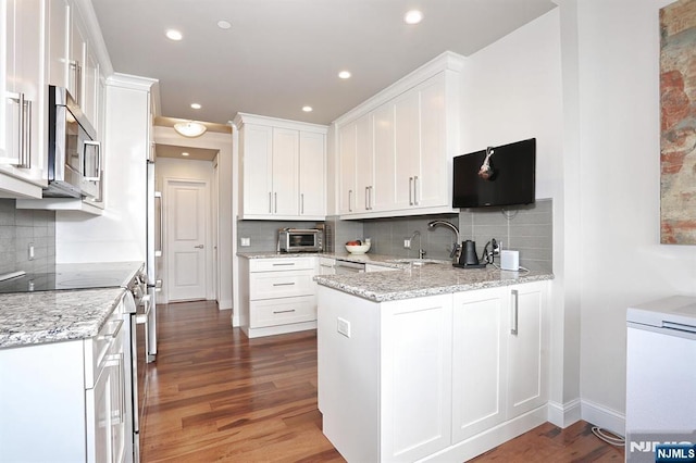 100 Carlyle Dr Unit 10Ds, Cliffside Park, NJ 07010 - kitchen featuring stainless steel appliances, a peninsula, decorative backsplash, white cabinets, and recessed lighting