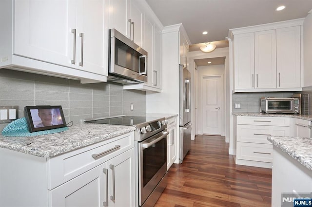 100 Carlyle Dr Unit 10Ds, Cliffside Park, NJ 07010 - kitchen with appliances with stainless steel finishes, white cabinetry, dark wood-type flooring, recessed lighting, and decorative backsplash