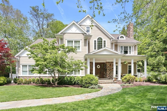 7 Newton Pl, Allendale, NJ 07401 - view of front of house featuring stone siding, a chimney, a porch, and a front lawn