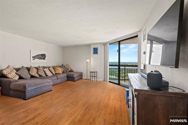 708 Harmon Cv, Secaucus, NJ 07094 - living area with expansive windows, a textured ceiling, and wood finished floors