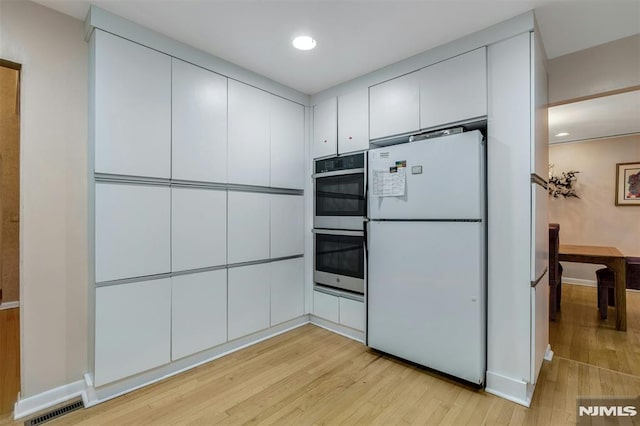 526 Rutland Ave, Teaneck, NJ 07666 - kitchen featuring freestanding refrigerator, double oven, light wood-style flooring, white cabinetry, and recessed lighting