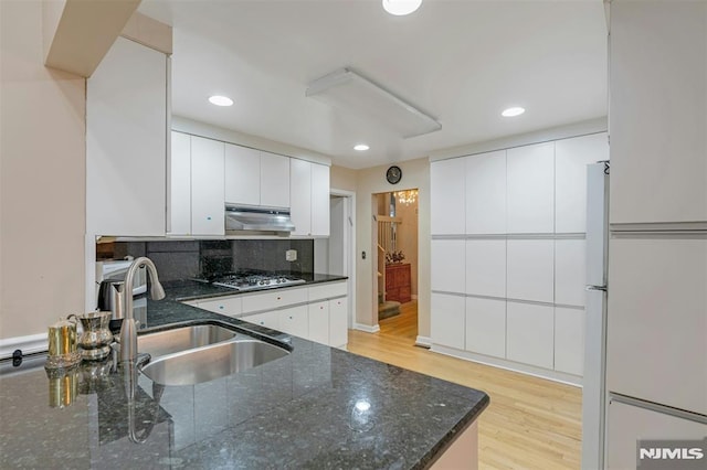526 Rutland Ave, Teaneck, NJ 07666 - kitchen with stainless steel gas stovetop, under cabinet range hood, light wood-type flooring, white cabinetry, and recessed lighting