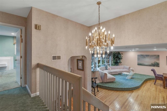 526 Rutland Ave, Teaneck, NJ 07666 - corridor with wood-type flooring, a chandelier, arched walkways, and a towering ceiling