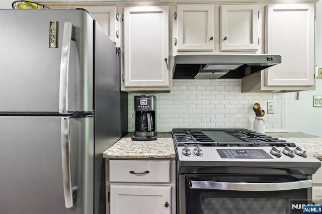 510 Mark Twain Way, Mahwah, NJ 07430 - kitchen with stainless steel appliances, under cabinet range hood, decorative backsplash, light stone countertops, and white cabinetry