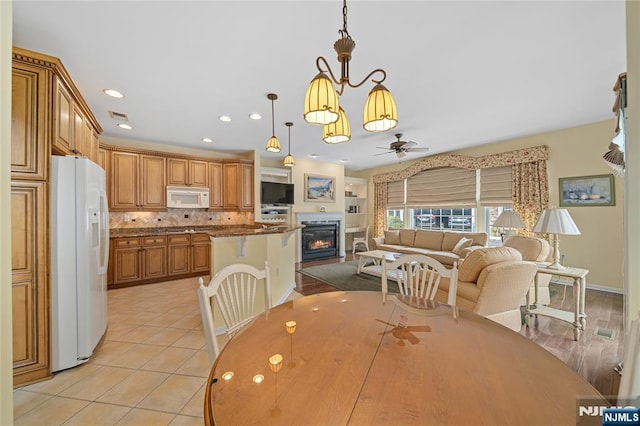 49 Quarry Dr, Woodland Park, NJ 07424 - dining space with ceiling fan, a glass covered fireplace, light tile patterned flooring, and recessed lighting