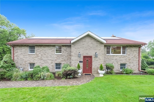 47 Venna Ave, North Haledon, NJ 07508 - view of front of house with solar panels, a front yard, and brick siding
