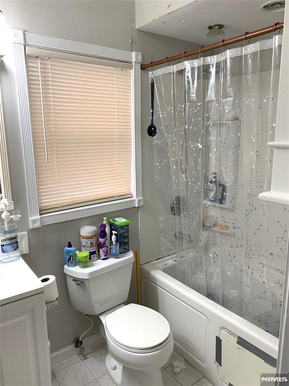 116 W 19th St Unit 1A, Bayonne, NJ 07002 - full bathroom featuring toilet, shower / bath combination with curtain, vanity, and tile patterned floors