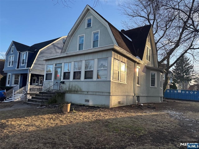 view of front of property featuring crawl space, a gambrel roof, and a shingled roof