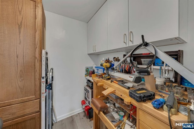 kitchen with light wood-style floors, light countertops, baseboards, and white cabinets