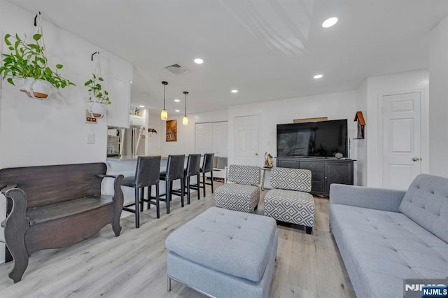 living room featuring light wood-style flooring and recessed lighting