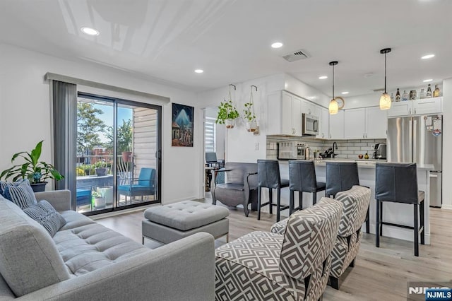 living room featuring light wood finished floors and recessed lighting