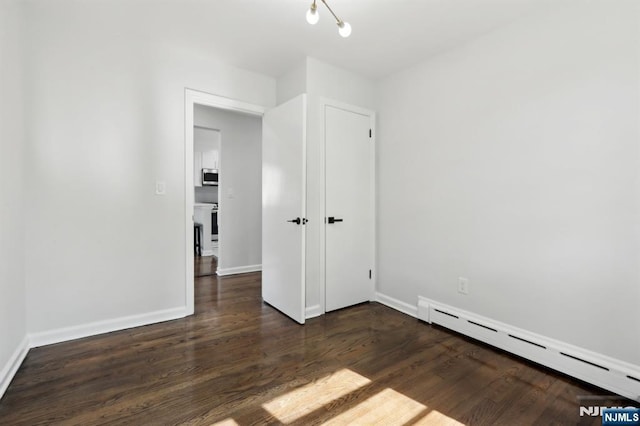 8 Oak St, Netcong Borough, NJ 07857 - unfurnished bedroom featuring baseboard heating, dark wood-style floors, and baseboards