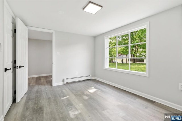 8 Oak St, Netcong Borough, NJ 07857 - empty room featuring a baseboard heating unit, wood finished floors, and baseboards