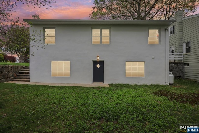 8 Oak St, Netcong Borough, NJ 07857 - back of property featuring stucco siding, stairs, and a yard