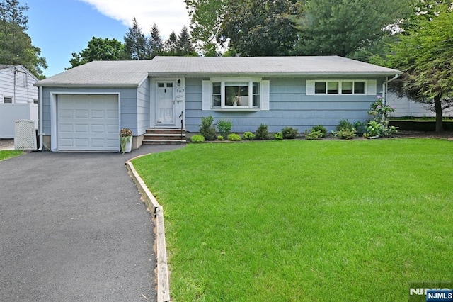 ranch-style house with a garage, a front yard, and asphalt driveway
