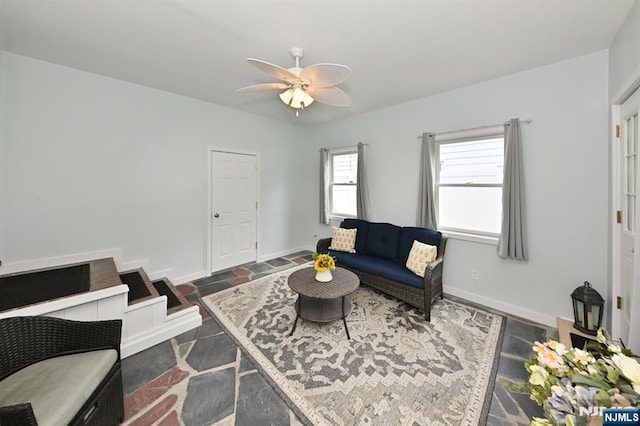 living room featuring ceiling fan and baseboards