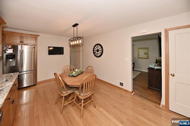 dining area featuring light wood-style flooring and baseboards