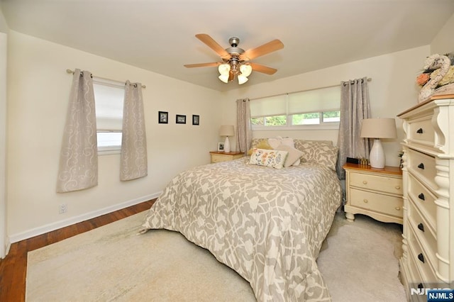 bedroom featuring wood finished floors, baseboards, and a ceiling fan
