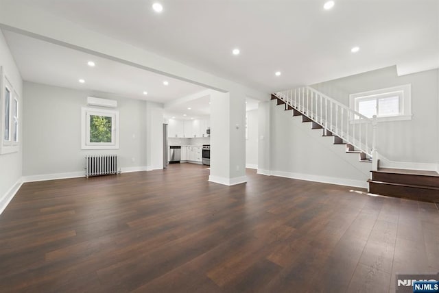240 Berry St, Hackensack, NJ 07601 - unfurnished living room featuring radiator, an AC wall unit, stairway, plenty of natural light, and recessed lighting
