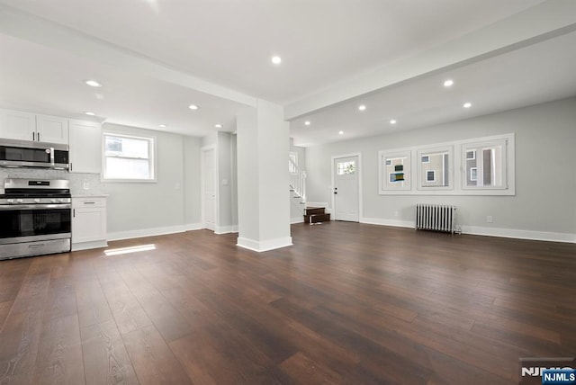 240 Berry St, Hackensack, NJ 07601 - unfurnished living room featuring radiator heating unit, stairs, dark wood-style floors, recessed lighting, and baseboards