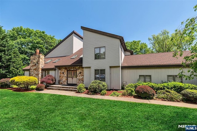 81 Columbus Ave, Totowa, NJ 07512 - view of front facade featuring a front lawn, a chimney, french doors, roof with shingles, and stone siding