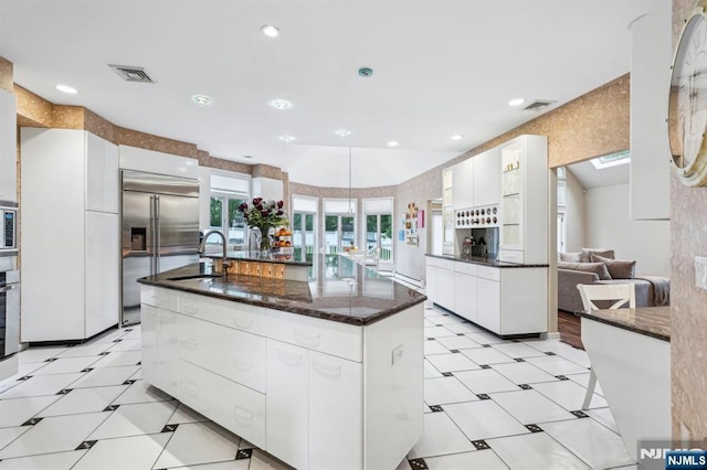 31 Bourbon St, Wayne, NJ 07470 - kitchen featuring a sink, stainless steel built in refrigerator, light floors, white cabinetry, and a kitchen island with sink