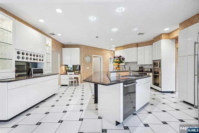 31 Bourbon St, Wayne, NJ 07470 - kitchen with stainless steel appliances, a sink, white cabinets, recessed lighting, and dark stone counters