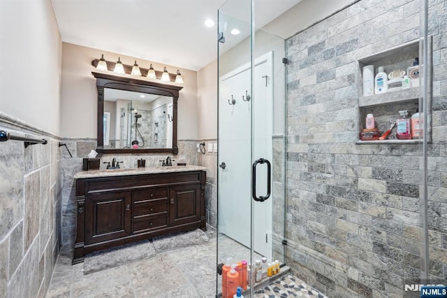 31 Bourbon St, Wayne, NJ 07470 - bathroom featuring tile walls, double vanity, a shower stall, wainscoting, and recessed lighting