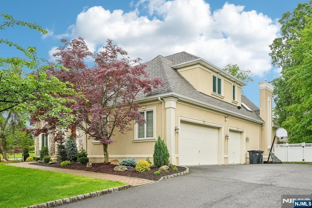 31 Bourbon St, Wayne, NJ 07470 - view of front of property featuring stucco siding, asphalt driveway, and an attached garage