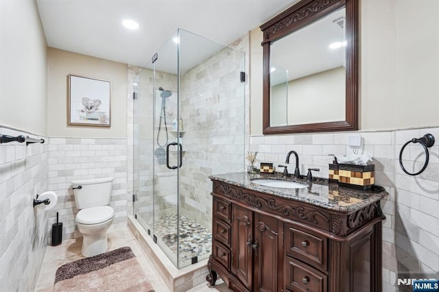 31 Bourbon St, Wayne, NJ 07470 - bathroom with tile walls, toilet, vanity, a stall shower, and wainscoting