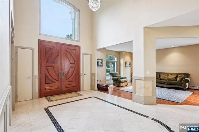 31 Bourbon St, Wayne, NJ 07470 - foyer entrance featuring a high ceiling, baseboard heating, light tile patterned floors, and inlaid floor details