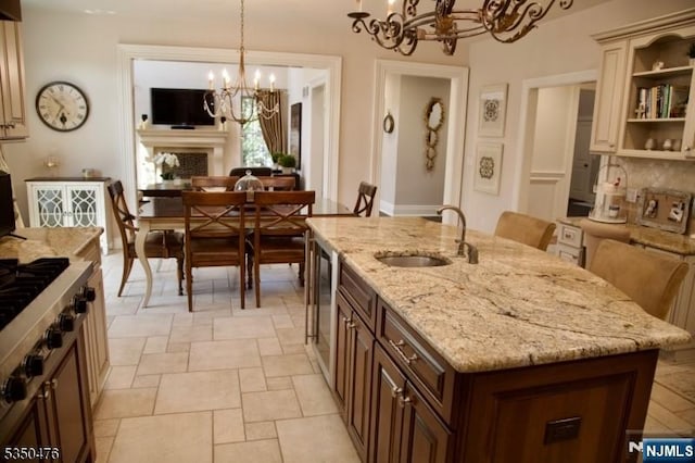5 Young Ct, East Hanover Twp, NJ 07936 - kitchen with a chandelier, a sink, stone tile floors, an island with sink, and hanging light fixtures
